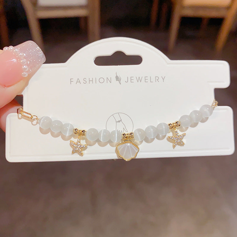 White cat’s eye bead bracelet with shell pendant
